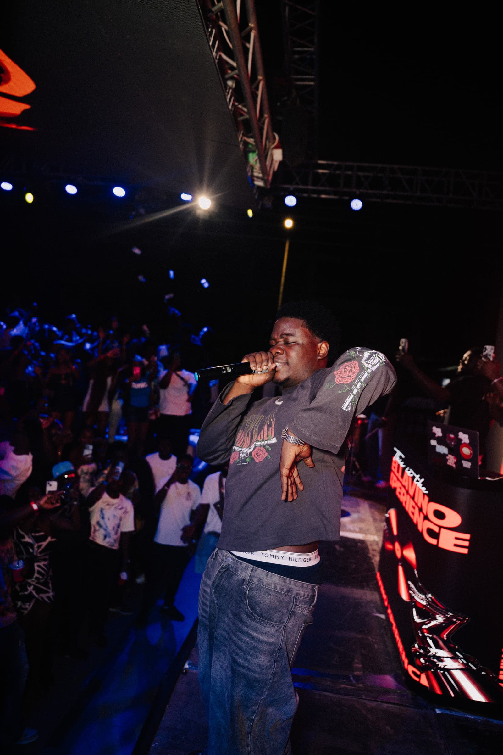 A rapper performs at the barrier under blue stage lights